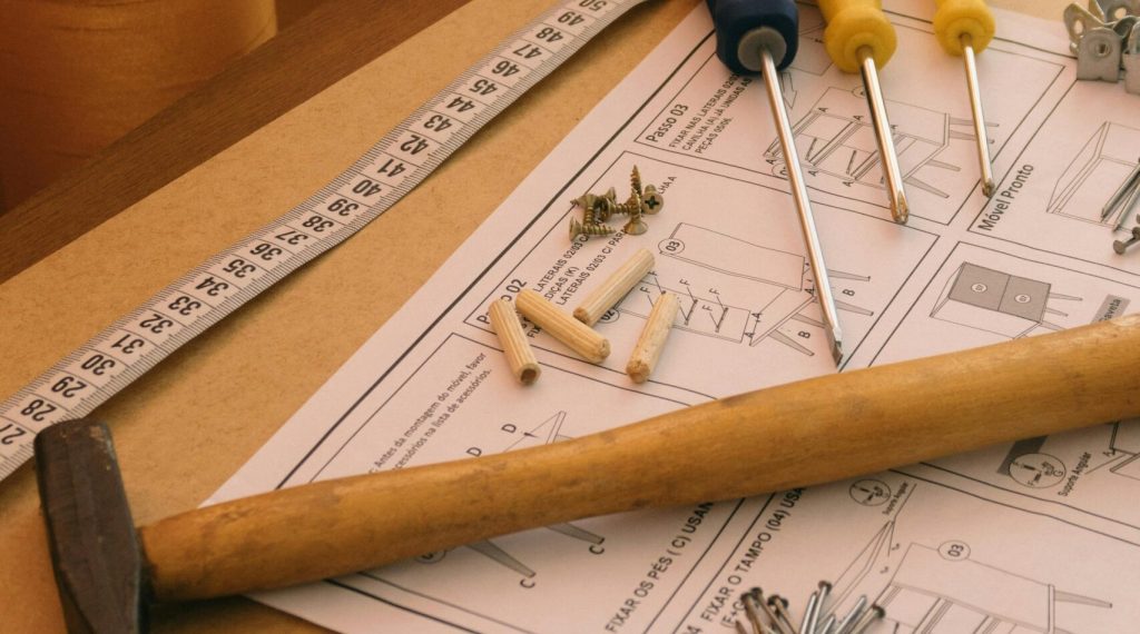 A set of tools and instructions for assembling DIY furniture, including a hammer and screwdrivers.